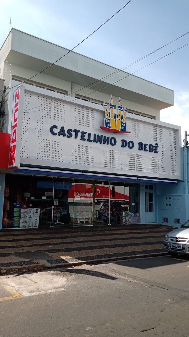 Fachada perfurada branca com toldo — Castelinho do Bebê