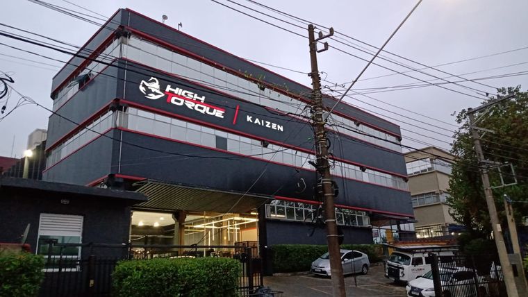 Fachada em ACM cinza com detalhes vermelhos — prédio High Torque / Kaizen